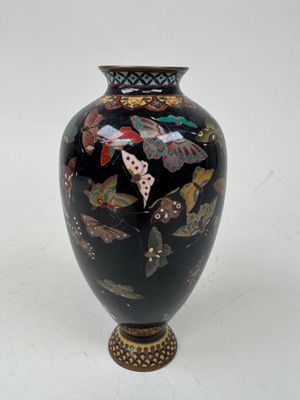 un vase noir orné d'un motif de papillon