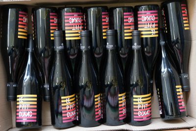 bottles of wine sitting in a cardboard box on a shelf
