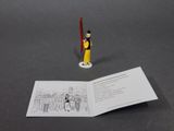 a toy figure that is standing next to an open book