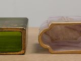 pair of green and gold vases on a table with a white background