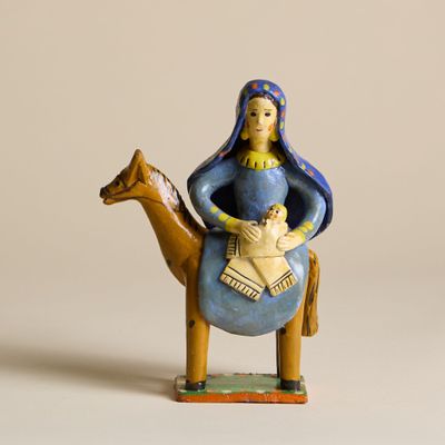 figurine représentant une femme assise sur un chameau avec un bébé