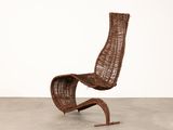 the chair is made of wicker and has a curved seat