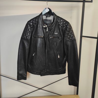 une veste en cuir noir accrochée à un porte-manteau dans une pièce