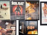 many movie posters on the wall of a room