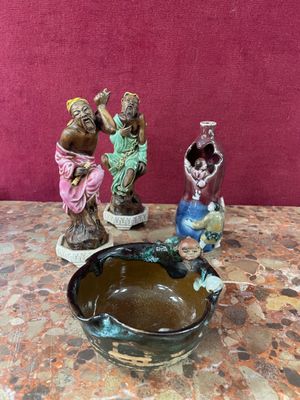 trois figurines posées sur une table, à côté d'un bol
