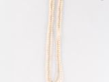 gros plan d'un collier de perles blanches sur une surface blanche