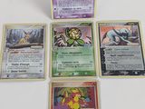 quatre cartes Pokémon posées les unes sur les autres sur une table
