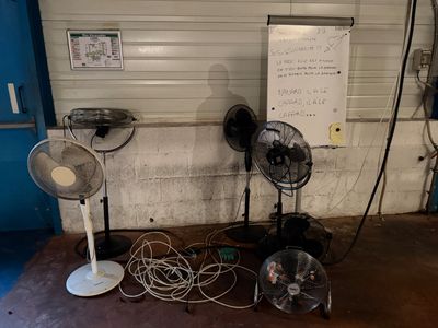 trois ventilateurs posés par terre les uns à côté des autres