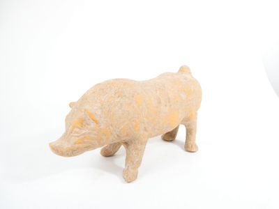 a small figurine of a pig on a white surface