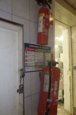 a fire extinguisor attached to a wall in a bathroom