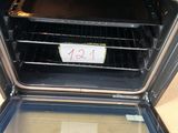 un four noir dont la porte est ouverte et sur laquelle est accrochée une pancarte