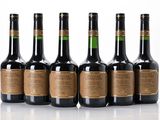 six bottles of wine are lined up in a row on a white surface