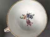 a white bowl with a flower on it on a table