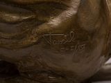 a bronze statue of a bird on a white surface