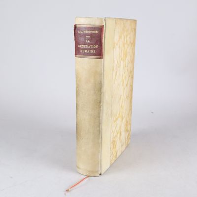 un vieux livre posé sur une table blanche à côté d'un mur blanc
