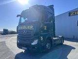 un camion vert garé devant un immeuble