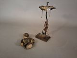 a statue of a monkey sitting next to a small statue of a bird