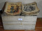 two old newspapers sitting on top of a wooden box