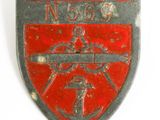 a red and black badge with a gun on it