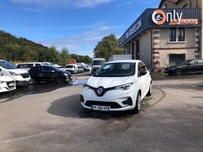 the white car is parked in front of a building with cars parked in front of it