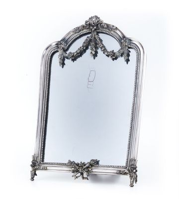 un miroir ancien en argent dont le cadre est orné d'un motif floral