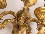 a gold colored chandelier with two candles on it
