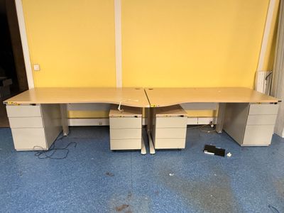 deux bureaux blancs à tiroirs et un mur jaune