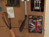 a cardboard box with a bunch of kitchen utensils on it