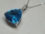 une photo d'un pendentif en topaze bleue en forme de cœur, monté sur une chaîne en argent