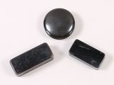 three black magnets sitting next to each other on a white surface
