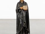 a statue of a man holding a book in his hands
