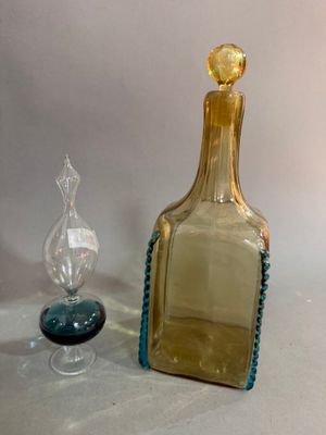 a glass bottle and a glass candle holder on a table
