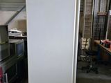 a white refrigerator in a garage next to other appliances