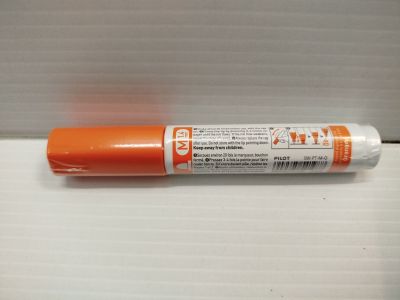 un gros plan d'un marqueur orange sur une surface blanche