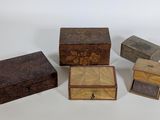 quatre petites boîtes en bois posées sur une surface blanche