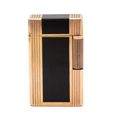 a black and gold lighter sitting on top of a white surface