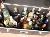 many bottles of alcohol in a metal case on the floor