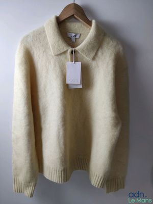 an image of a sweater hanging on a hanger on a wall