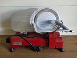 une machine rouge posée sur un plancher en bois