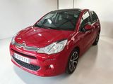 La voiture rouge est garée dans une pièce blanche au sol blanc.