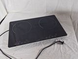 a black stove top with two burners on it