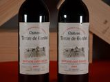 two bottles of wine sitting next to each other on a table