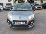 La voiture est garée sur le parking, à côté de nombreuses autres voitures.