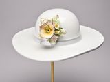 a white hat with a flower on top of it