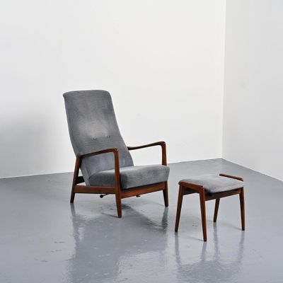 un fauteuil et un pouf dans une pièce aux murs blancs