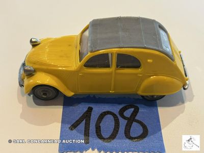 une petite voiture jaune posée sur un ruban bleu