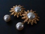 pair of pearl and gold earrings on a black surface