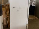 an image of a white refrigerator in a warehouse