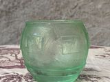un petit bol en verre vert posé sur une table