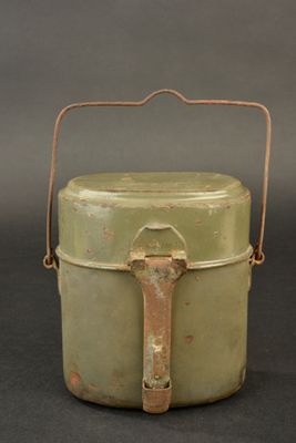 a small green container with a handle on a table